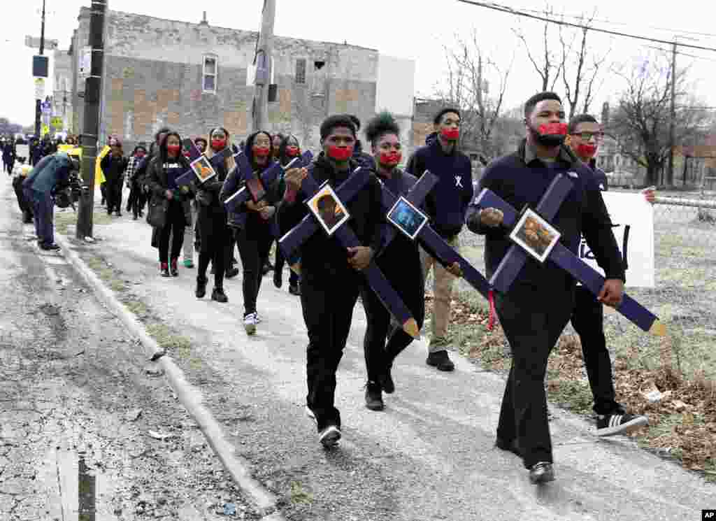 High school senior D&#39;Angelo McDade, front right, leads a march in Chicago&#39;s North Lawndale neighborhood, Illinois, during a walkout to protest gun violence, March 14, 2018.