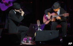 FILE - Leonard Cohen, left, performs with guitarist Xavier Mas at the Beacon Theatre, his first concert in New York in 15 years, Feb. 19, 2008.