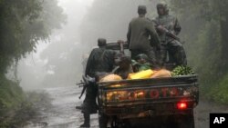 Congolese M23 rebels carry goods in the back of a truck near the Congo-Uganda border town of Bunagana, DRC, December 5, 2012.