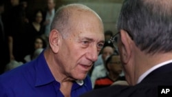 Cựu thủ tướng Israel Ehud Olmert nói chuyện với một luật sư khi đến tòa án ở Tel Aviv, Israel, 13/5/14