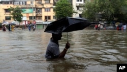 A man wades through a waterlogged street following heavy rains in Mumbai, India, Aug. 29, 2017.