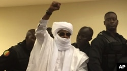Chad's former dictator Hissene Habre raises his hand during court proceedings in Dakar, Senegal, May 30, 2016. 