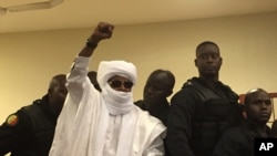 L'ancien dictateur Hissène Habré lève sa main lors de son procès à Dakar, au Sénégal, le 30 mai 2016.