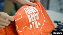 A volunteer stocks a table with shirts during a media tour of the Whole Woman’s Health clinic in San Antonio, Texas, Feb. 9, 2016. The group has launched a campaign to win support to keep its clinics open.