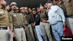 Cảnh sát áp tải tài xế taxi Uber Shiv Kumar Yadav ra tòa ở New Delhi.