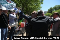 FILE - A pro-Turkey demonstrator tries to rip a sign from the hands of a pro-Kurdish demonstrator outside the White House, where U.S. President Donald Trump was hosting Turkish President Recep Tayyip Erdogan, May 16, 2017.