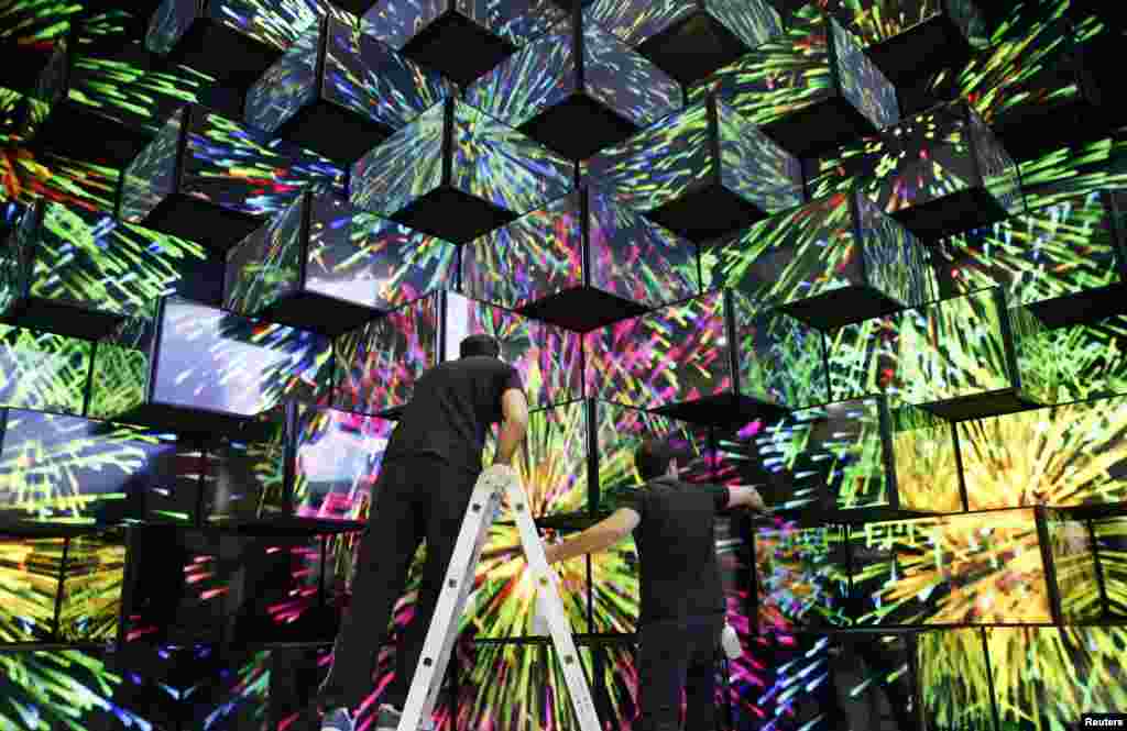 Workers make final preparations on a wall made of TV screens at the booth of Vestel at the IFA consumer electronics fair in Berlin, Germany. The IFA consumer electronics and home appliances fair will open its doors to the public from Sept. 6 till 11.