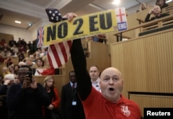 A demonstrator holds a pro-Brexit sign and a U.S. flag, as the speech by the Mayor of London, Sadiq Khan, is interrupted at the Fabian Society New Year Conference, in central London, Britain Jan. 13, 2018.