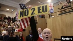 A demonstrator holds a pro-Brexit sign and a U.S. flag, as the speech by the Mayor of London, Sadiq Khan, is interrupted at the Fabian Society New Year Conference, in central London, Britain Jan. 13, 2018.