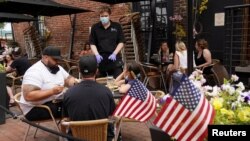 ریاست ورجینیا میں کاروباروں کو محدود پیمانے پر اجازت ملنے کے بعد الیکزینڈیا میں ایک ریستوران گاہکوں کو عمارت سے باہر سروس فراہم کر رہا ہے۔ 29 مئی 2020