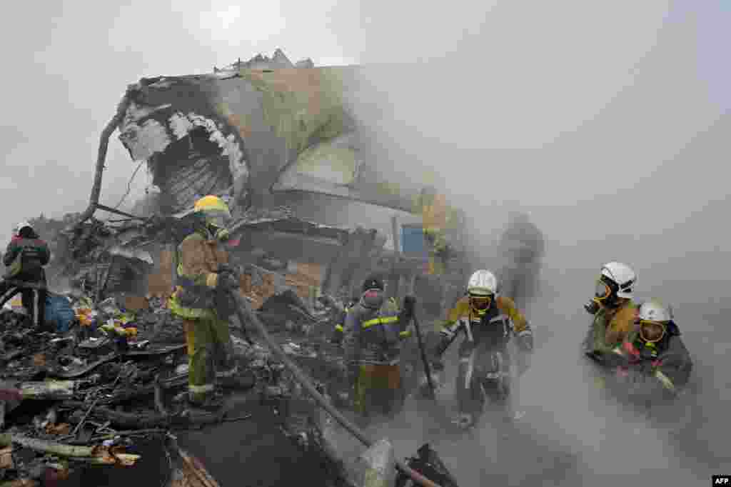 Rescue personnel work at the crash site of a Turkish cargo plane in the village of Dacha-Suu outside Bishkek, Kyrgyzstan. At least 37 people in the residential area adjacent to the Manas airport as well as those on the plane, were killed.