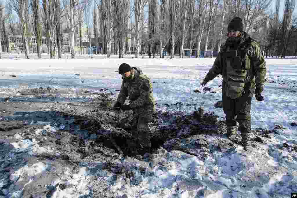 우크라이나 동부지역에서 정부군과 러시아 지원 분리주의 반군의 싸움이 격화되고 있는 가운데, 정부군 병사들이 아우디이우카 시내 폭발 현장을 점검하고 있다. 최근 충돌로 최소한 8명이 숨지고 10여명이 부상당한 한편, 광부 200여명이 갱도에 고립됐다.&nbsp;