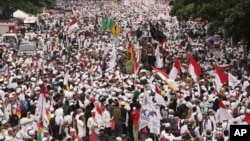 Muslim protesters march during a demonstration in Jakarta, Indonesia, Nov. 4, 2016. Tens of thousands of hard-line Muslims converged Friday on the center of the Indonesian capital to demand the arrest of its minority-Christian governor for alleged blasphemy.