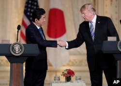 Japanese Prime Minister Shinzo Abe (L), and President Donald Trump shake hands during a news conference at Trump's private Mar-a-Lago club, April 18, 2018, in Palm Beach, Florida.