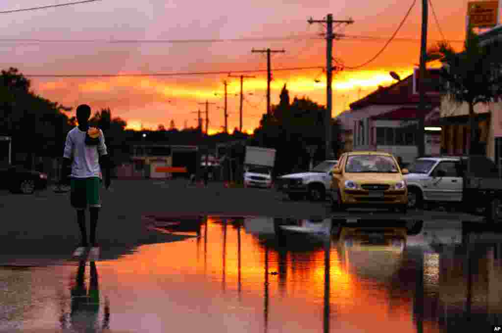 Jan. 6: A man arrives at flooded waters at Depot Hill in Rockhampton, Queensland, Australia. Queensland's record floods are causing catastrophic damage to infrastructure and have forced 75 percent of its coal mines, which fuel Asia's steel mills, to be ha