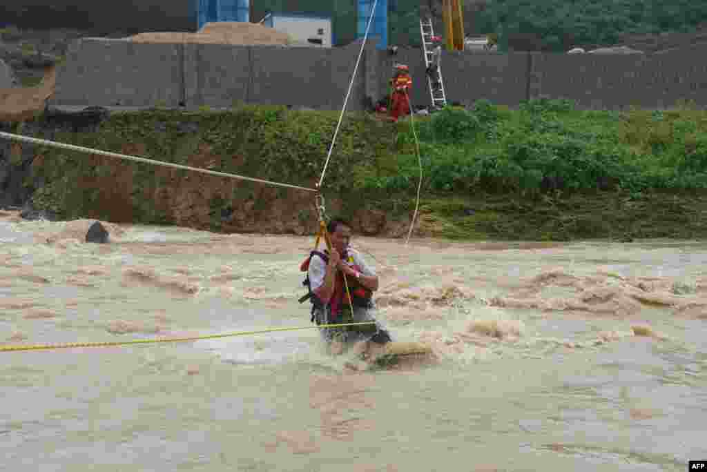 Rescuers help residents to evacuate in Tianlin county in China&#39;s southern Guangxi region, June 24, 2018. Floods and landslides caused by sustained rains have killed three people and affected more than 90,000 people in Guangxi.