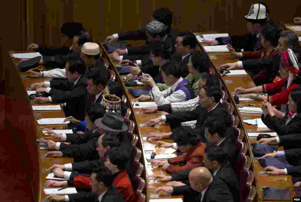 人大代表2013年3月5日在人民大会堂召开的第十二届人大开幕式上按钮批准建议草案。