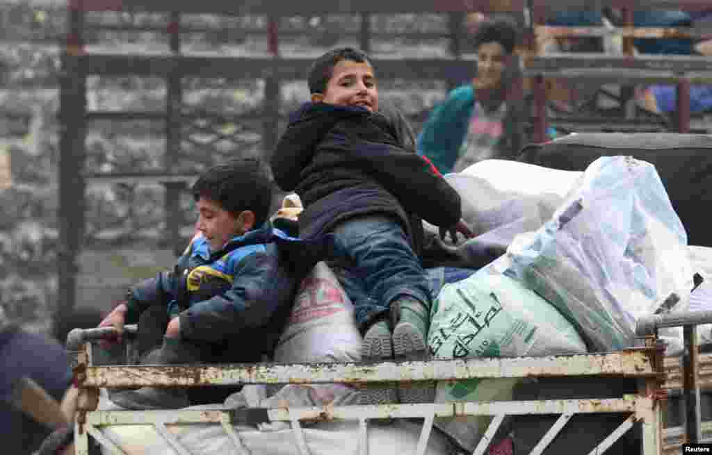 Boys sit on belongings and wait to be evacuated from a rebel-held sector of eastern Aleppo, Syria Dec. 16, 2016. 