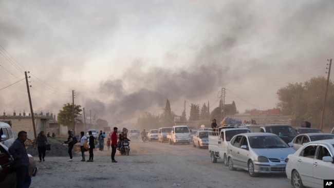 Syrians flee the community of Ras al Ayn, in northern Syria, before Turkey's offensive on Wednesday, October 9