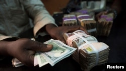 FILE - A trader changes dollars with naira at a currency exchange store in Lagos, Nigeria. Taken February 12, 2015.