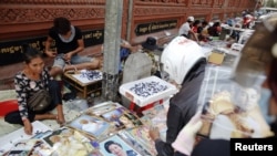 Vendors sell pictures of the royal family, as the country prepares for the funeral of Cambodia's late King Norodom Sihanouk, near the Royal Palace in Phnom Penh, January 31, 2013. 