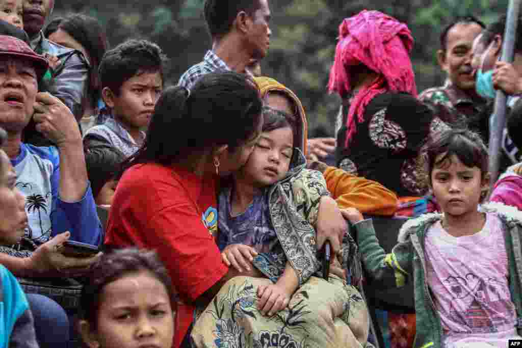 Family members gather as they wait for rescue teams searching for missing passengers at the Lake Toba ferry port in the province of North Sumatra, after a boat capsized on June 18.