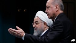 Turkey Iran SyriaTurkey's President Recep Tayyip Erdogan, right, gestures to Iran's President Hassan Rouhani, as they arrive for a news conference following their meeting at the Presidential Palace in Ankara, Dec. 20, 2018.
