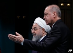 FILE - Turkey Iran SyriaTurkey's President Recep Tayyip Erdogan (R) and Iran's President Hassan Rouhani arrive for a news conference following their meeting in Ankara, Dec. 20, 2018.