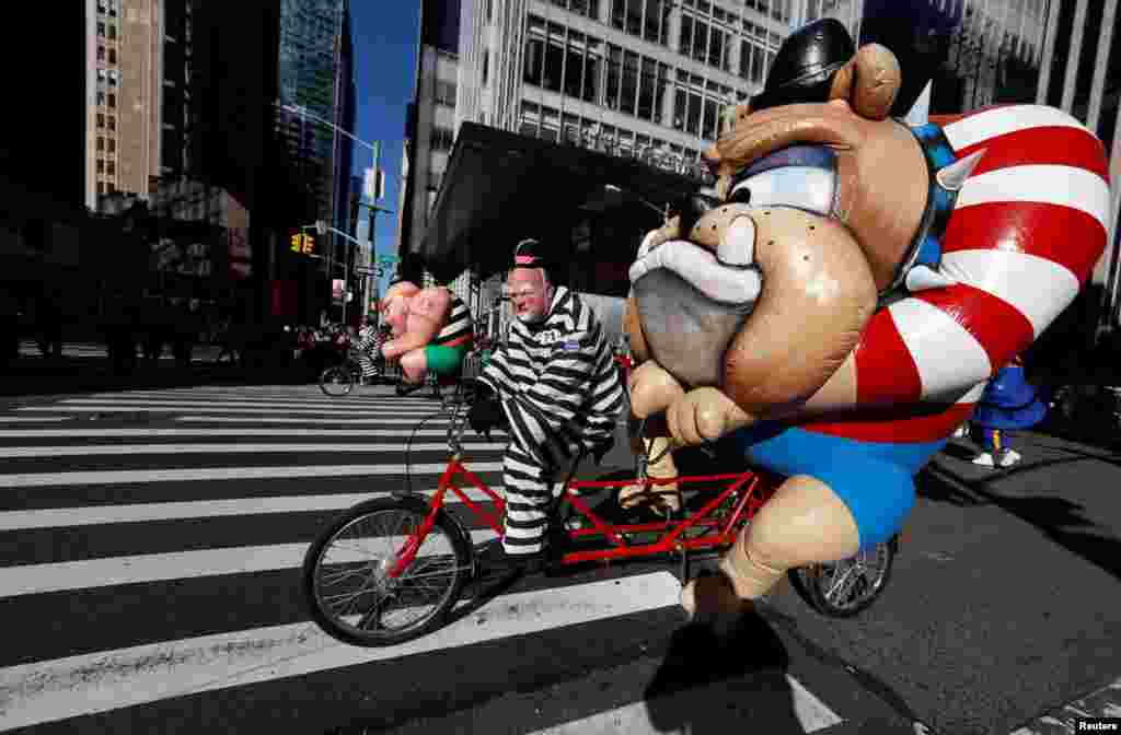 People dressed as cartoon characters on tandem bicycles make their way down 6th Ave during the 91st Macy&#39;s Thanksgiving Day Parade in the Manhattan borough of New York City, Nov. 23, 2017.