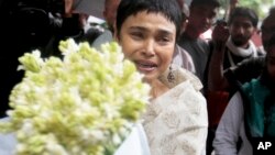 An unidentified woman brings flowers to pay respect to the people who died at Holey Artisan Bakery in Dhaka.
