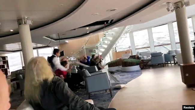 Passengers protect themselves from a collapsing ceiling aboard the cruise ship Viking Sky while listed, after an engine failure, near Hustadvika, Norway, March 23, 2019, in this still image obtained from a social media video.