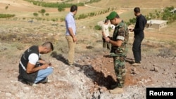Lebanese soldiers inspect a site which was hit by a rocket, which residents say was fired from Syria overnight, in the town of Seriine in the Bekaa valley, Lebanon, Jun. 1, 2013.