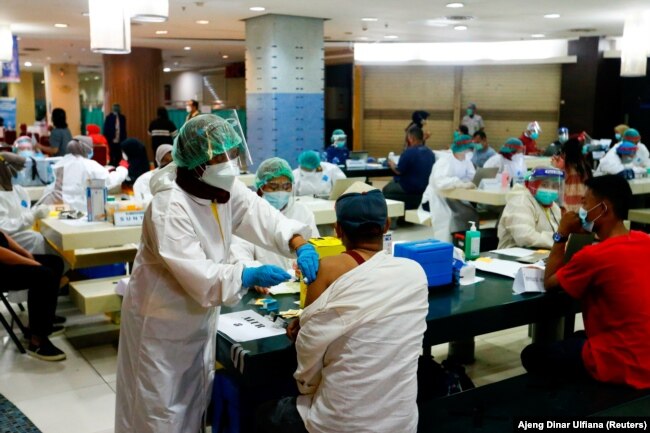 Seorang pedagang menerima dosis vaksin Sinovac Biotech China untuk COVID-19 di Pasar Tanah Abang, 17 Februari 2021. (Foto: REUTERS/Ajeng Dinar Ulfiana)