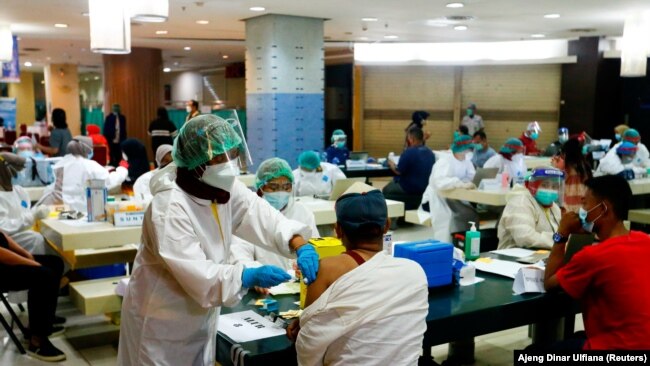 Seorang pedagang menerima vaksinasi COVID-19 di Pasar Tanah Abang, Jakarta (foto: dok). Sekitar 62 persen warga Indonesia telah menerima vaksinasi dosis lengkap hingga akhir Mei 2022.