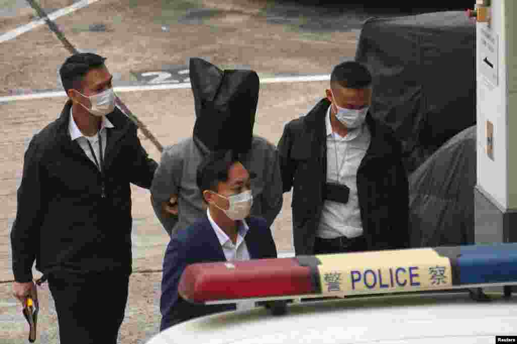 One of the 12 Hong Kong activists who were detained last year in mainland China for an illegal border crossing arrives at Tin Shui Wai police station in Hong Kong.