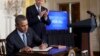 President Barack Obama signs a memorandum directing the federal government not to discriminate against those long-term unemployed workers in its own hiring practices, as Vice President Joe Biden stands right, in the East Room of the White House in Washing