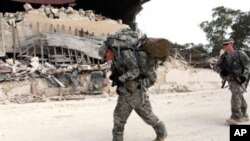 US soldiers of the 82nd Airborne Division walk in streets after leaving the Presidential palace en route to the general hospital in downtown Port-au-Prince, 19 Jan 2010