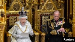 Britain's Queen Elizabeth sits with Prince Philip as she delivers her speech in the House of Lords, during the State Opening of Parliament at the Palace of Westminster in London May 8, 2013. 