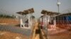 An Ebola patient, who only provided his first name as Peter, right, talks to his wife from within the quarantined zone in the Kerry town Ebola treatment center outside Freetown, Sierra Leone, Dec. 22, 2014. 