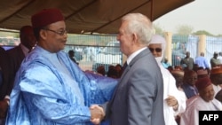 Le président Mahamadou Issoufou du Niger salue Michel Roussin à l'occasion de l'inauguration d'un tronçon ferroviaire de 140 km construit par le groupe français Bolloré et qui reliera à terme Niamey à Cotonou, le 29 janvier 2016.