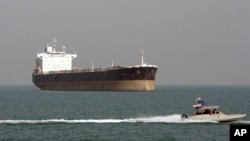 FILE - An Iranian Revolutionary Guard speedboat passes near an oil tanker, July 2, 2012. A collision late Saturday off the eastern coast of China left 30 Iranians missing.