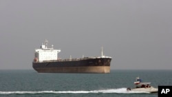 FILE - An Iranian Revolutionary Guard speedboat passes near an oil tanker, July 2, 2012.