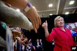 FILE Democratic presidential candidate Hillary Clinton, center, arrives to speak at a get out the vote event at Transylvania University in Lexington, Kentucky, May 16, 2016.