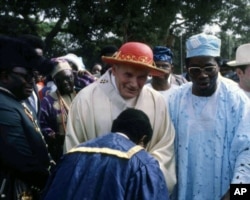 Pope John Paul II is greeted by an official during a visit to Ibadan, Nigeria, Feb. 15, 1982.