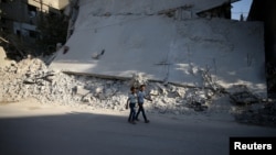 12일 시리아 수도 다마스쿠스 인근 반군장악 지역에서 무너져내린 건물 앞으로 어린이들이 걸어가고 있다. 