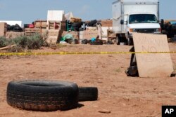 Police tape restricts access to a disheveled living compound in Amalia, N.M., Aug. 7, 2018.