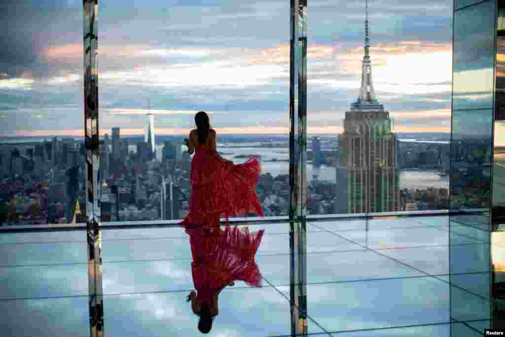 A woman looks at the Empire State Building and the New York skyline during a preview of SUMMIT One Vanderbilt observation deck. The deck is spread across the top four floors of the new One Vanderbilt tower in Midtown Manhattan, in New York City, New York, Oct. 18, 2021.