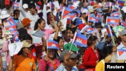 Garment workers shout and wave Cambodian national flags as they take part in a protest calling on the government to raise wages during a march to mark Labor Day in Phnom Penh May 1, 2015. 