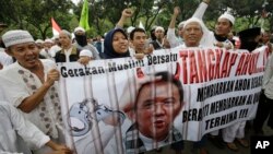 Para demonstran menyerukan penahanan Gubernur Jakarta Basuki 'Ahok' Tjahaja Purnama di luar Balai Kota (14/10). (AP/Achmad Ibrahim)