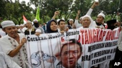 Indonesia Protest: In this Friday, Oct. 14, 2016, photo, Muslim protesters hold a banner calling for the arrest of Jakarta's ethnic Chinese and Christian Governor Basuki Tjahaja Purnama, popularly known as "Ahok", outside the City Hall. Indonesian police are planning a massive show of force in the capital Jakarta on Friday to contain a much-hyped protest by Muslim hardliners against the city's popular governor.